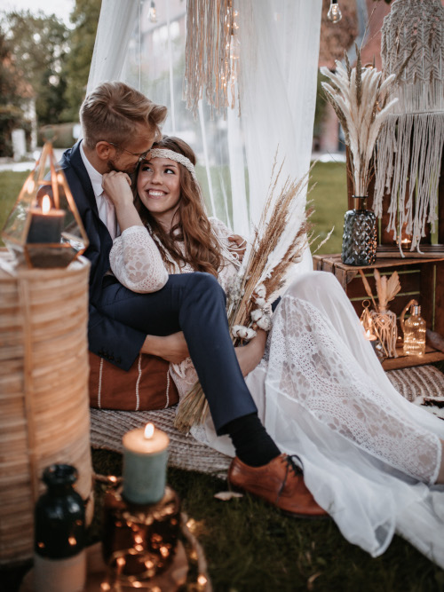 Ein Brautpaar auf einer gemütlichen Sitzarea auf dem Gras