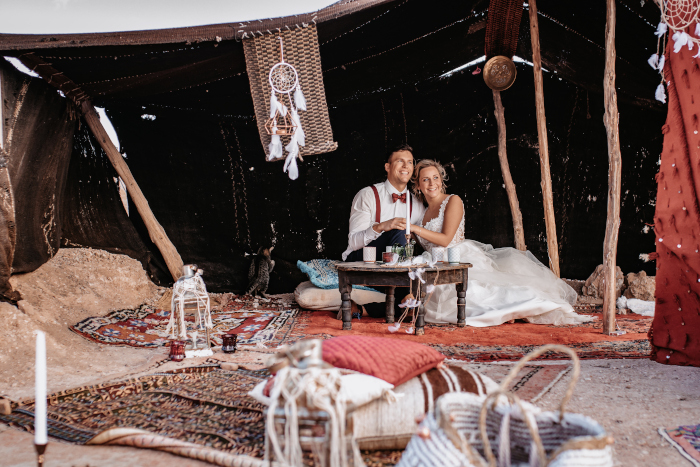 Ein Brautpaar sitzt im Wüsten-Camp